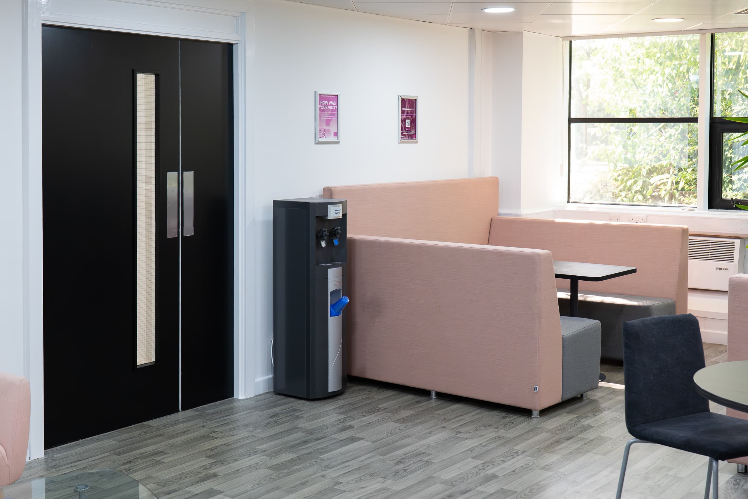 Modern communal breakout lounge with signature pink upholstered seating at Genesis Centre, Birchwood Warrington