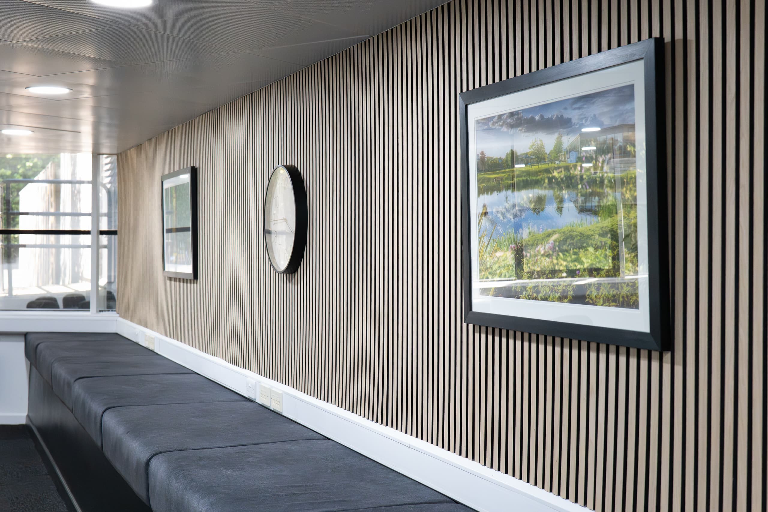 Contemporary Genesis Centre corridor with integrated timber slat wall and built-in seating, Birchwood Warrington