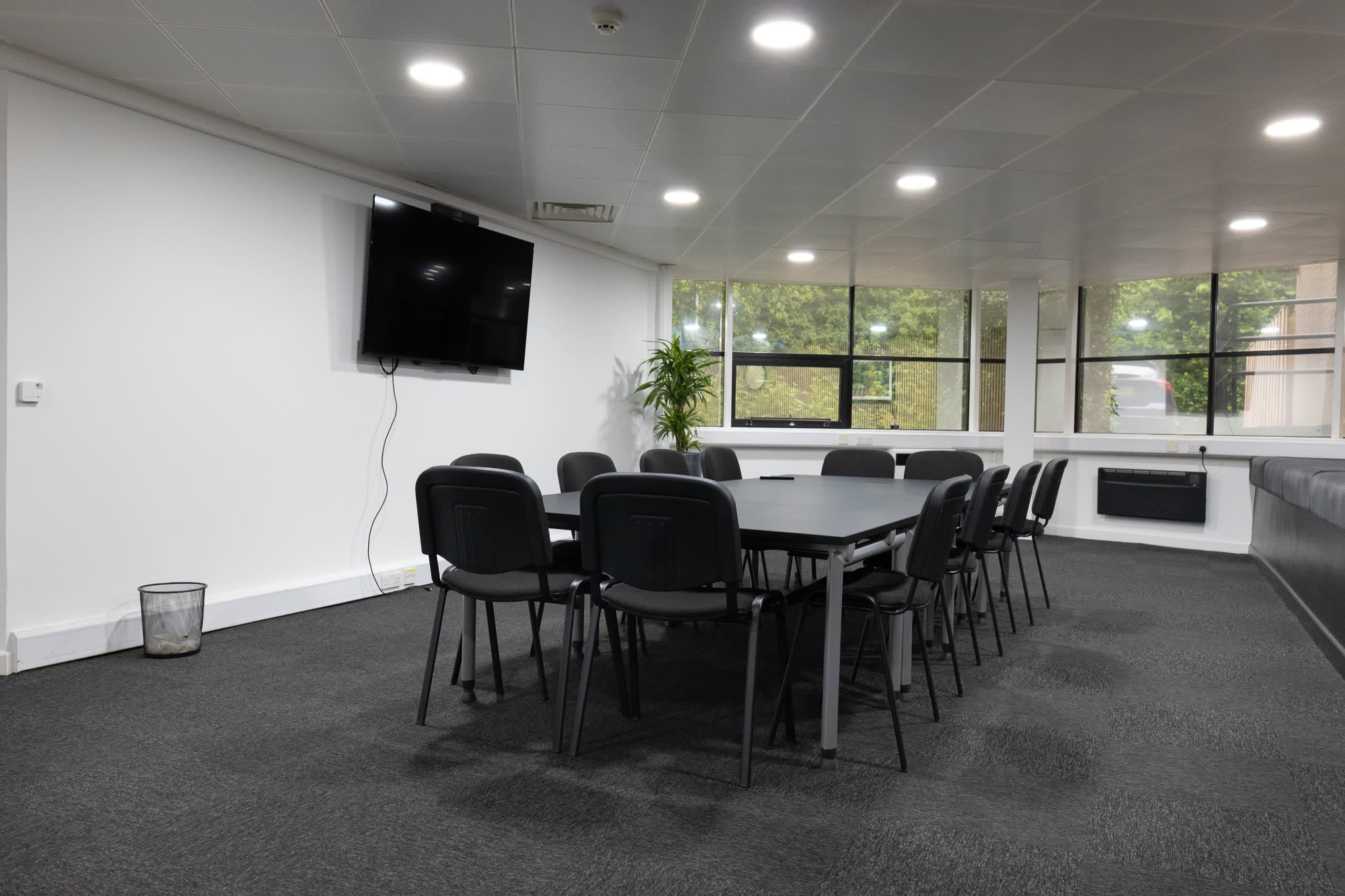Professional meeting room with 6-person table and timber slat wall at Genesis Centre, Birchwood Warrington