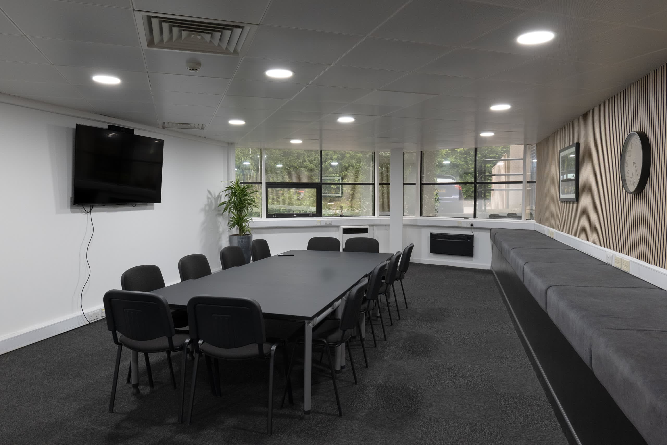 Wide architectural view of Genesis Centre meeting room C with full glazed panel and pendant lighting, Birchwood Warrington