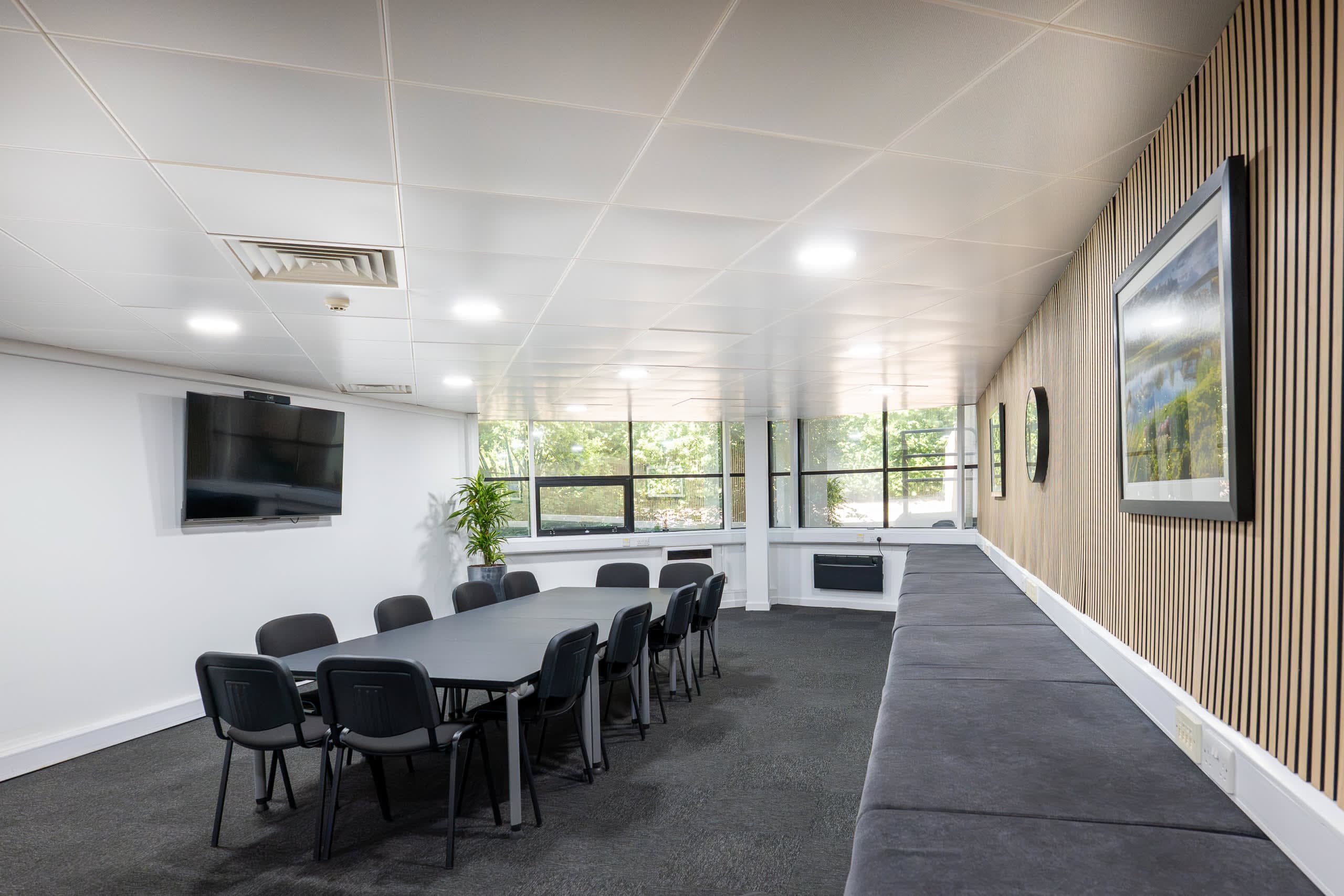 Genesis Centre meeting room with wood slat wall panel and curated artwork installation, Birchwood Warrington