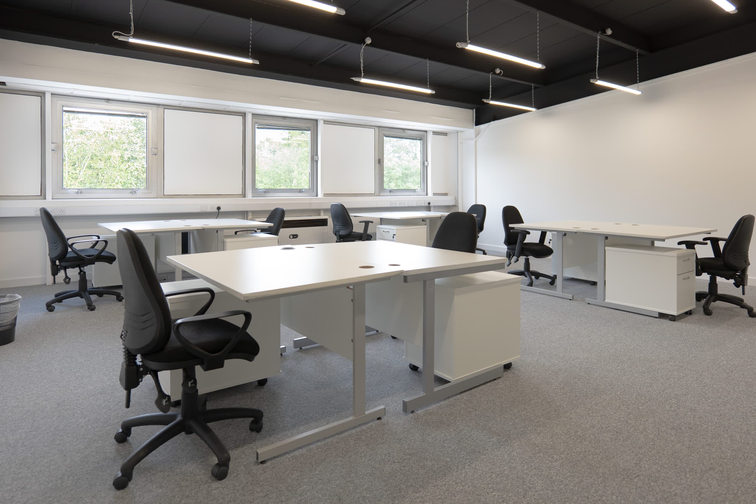 Open-plan office space at Genesis Centre with large floor-to-ceiling garden-view windows and bright natural light, Birchwood Warrington