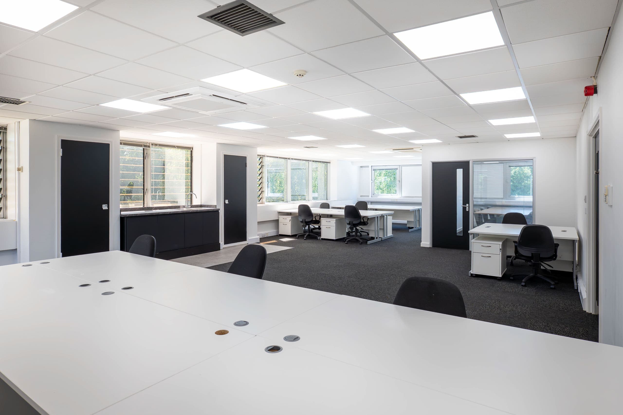 Large open-plan office suite at Genesis Centre with kitchenette, LED ceiling lighting and garden-view windows — view A, Birchwood Warrington