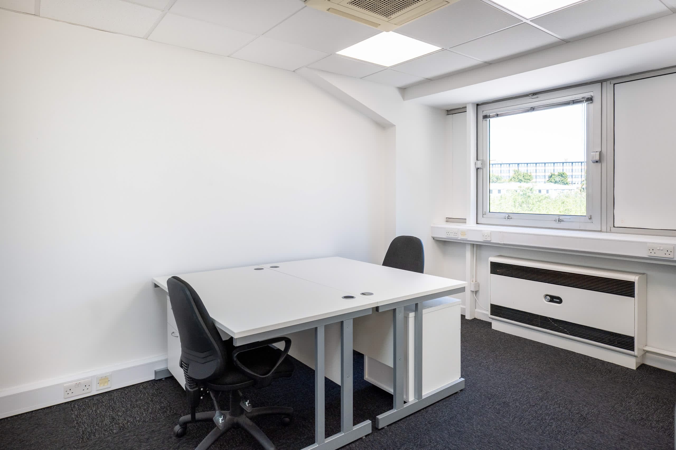 Small private office suite at Genesis Centre with 2-person desk setup and single window, Birchwood Warrington