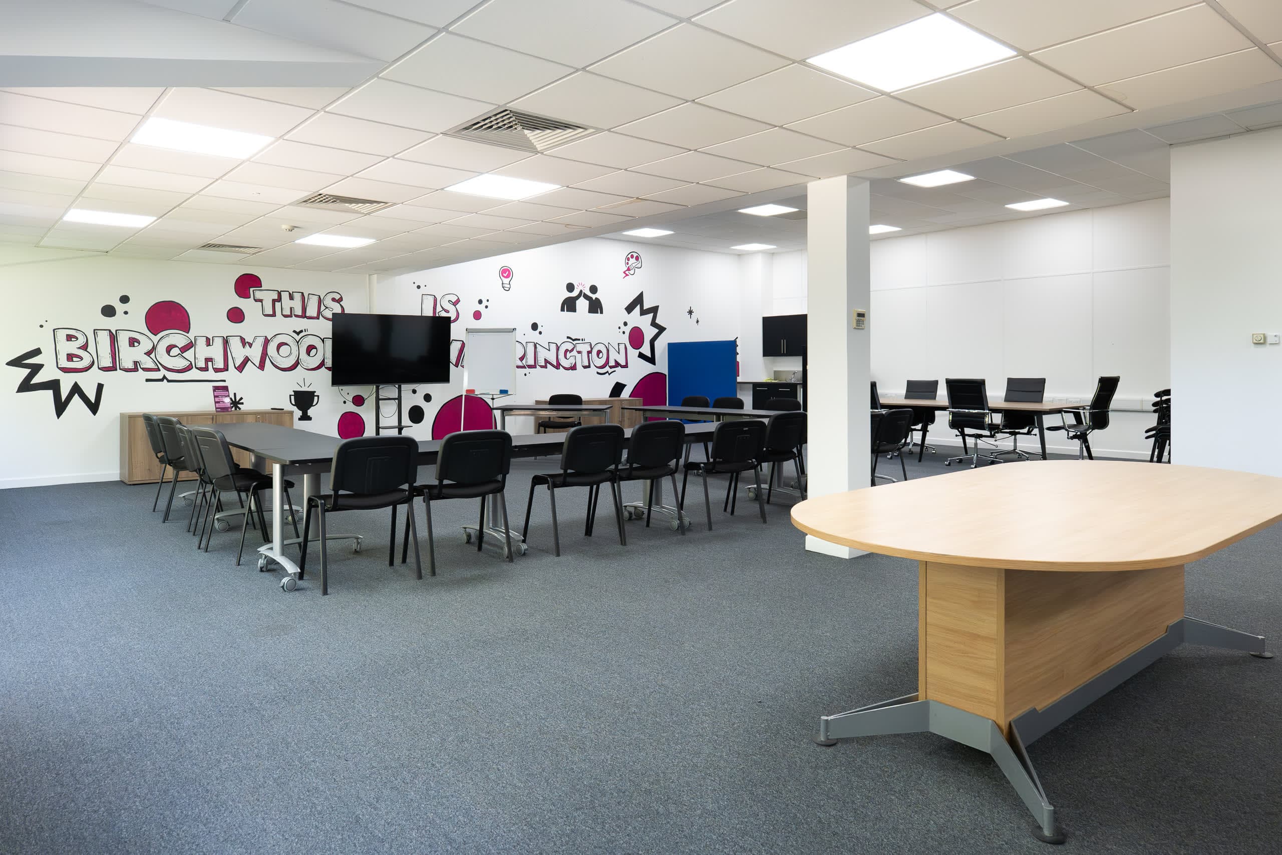 Genesis Centre training room configured in a professional classroom layout with tables and chairs, Birchwood Warrington