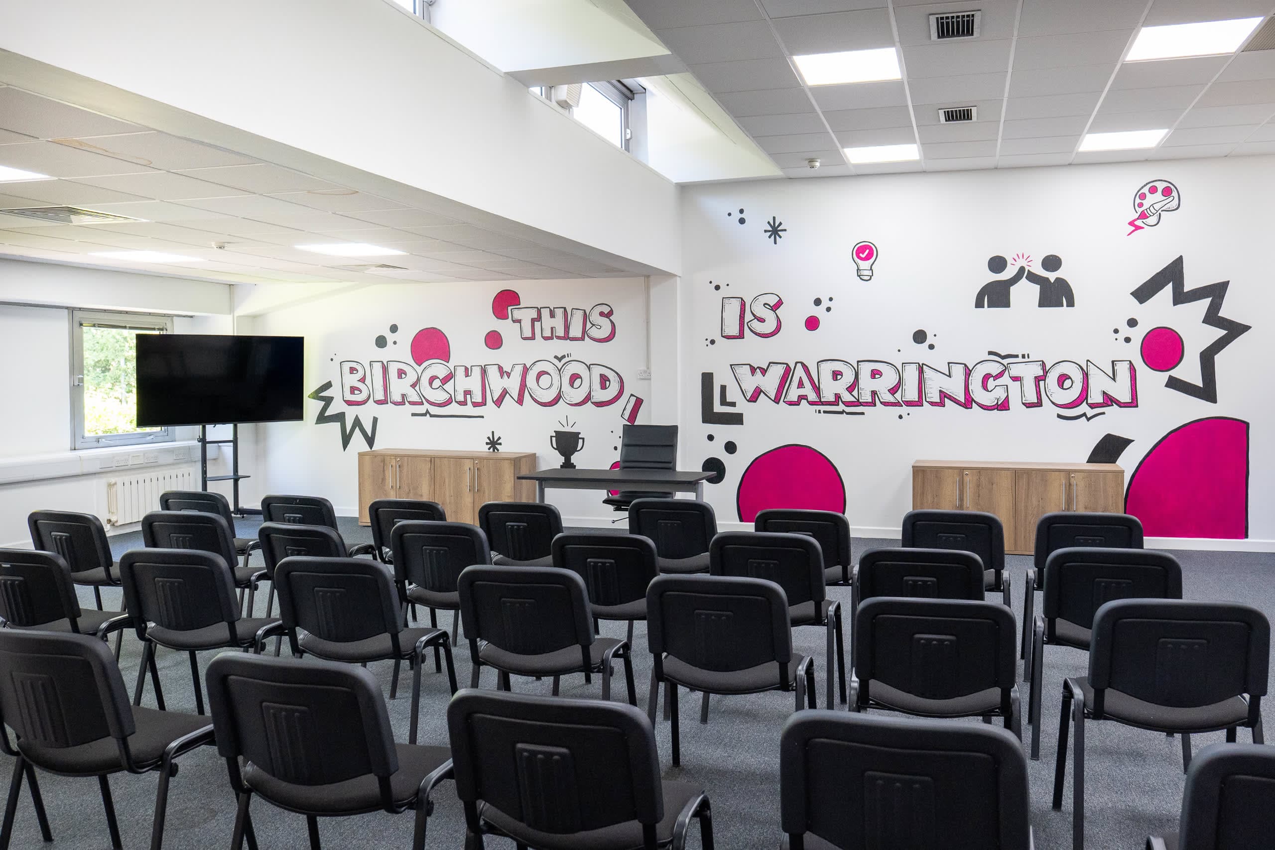 Close-up of padded theatre-style seating rows in the Genesis Centre training facility, Birchwood Warrington