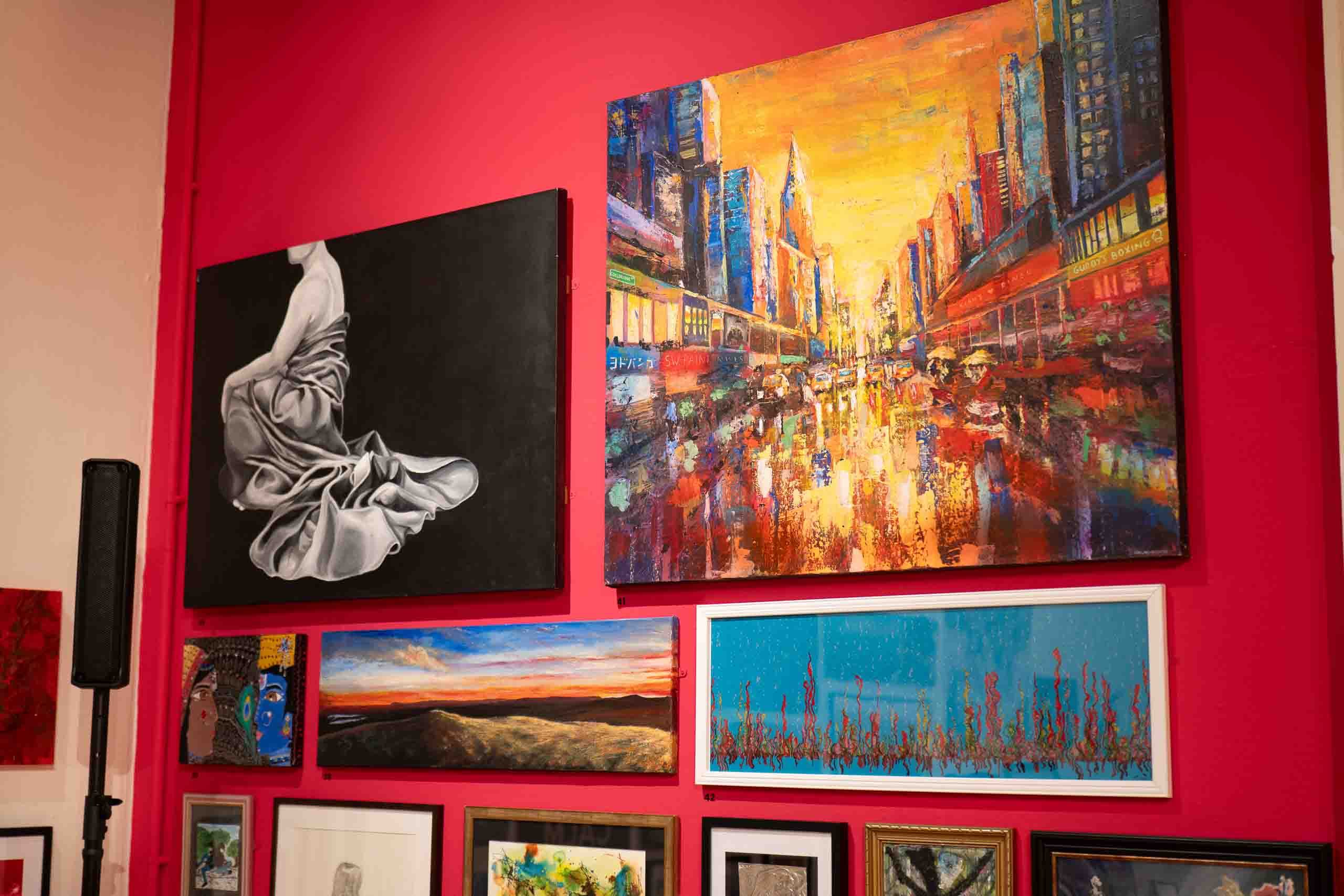Harris Museum Open Exhibition 2026 — red feature wall showing large monochrome figure painting alongside vibrant colourful cityscape oil painting