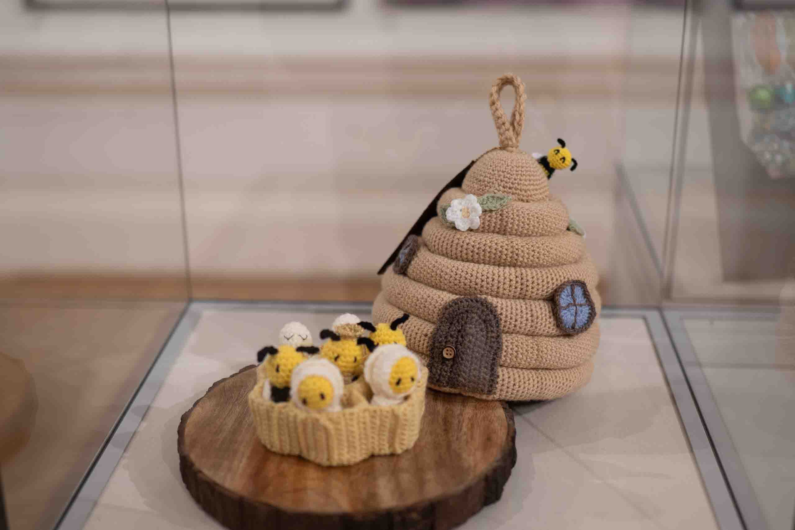 Harris Museum Open Exhibition 2026 — close-up of a crocheted beehive sculpture with miniature bee figures displayed in a glass exhibition case