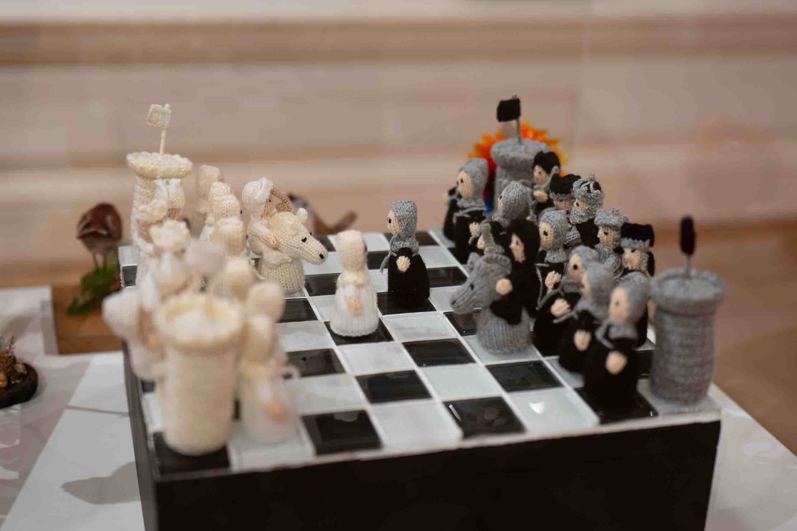 Harris Museum Open Exhibition 2026 — close-up of an intricately hand-knitted chess set with white and grey character pieces on a black and white board