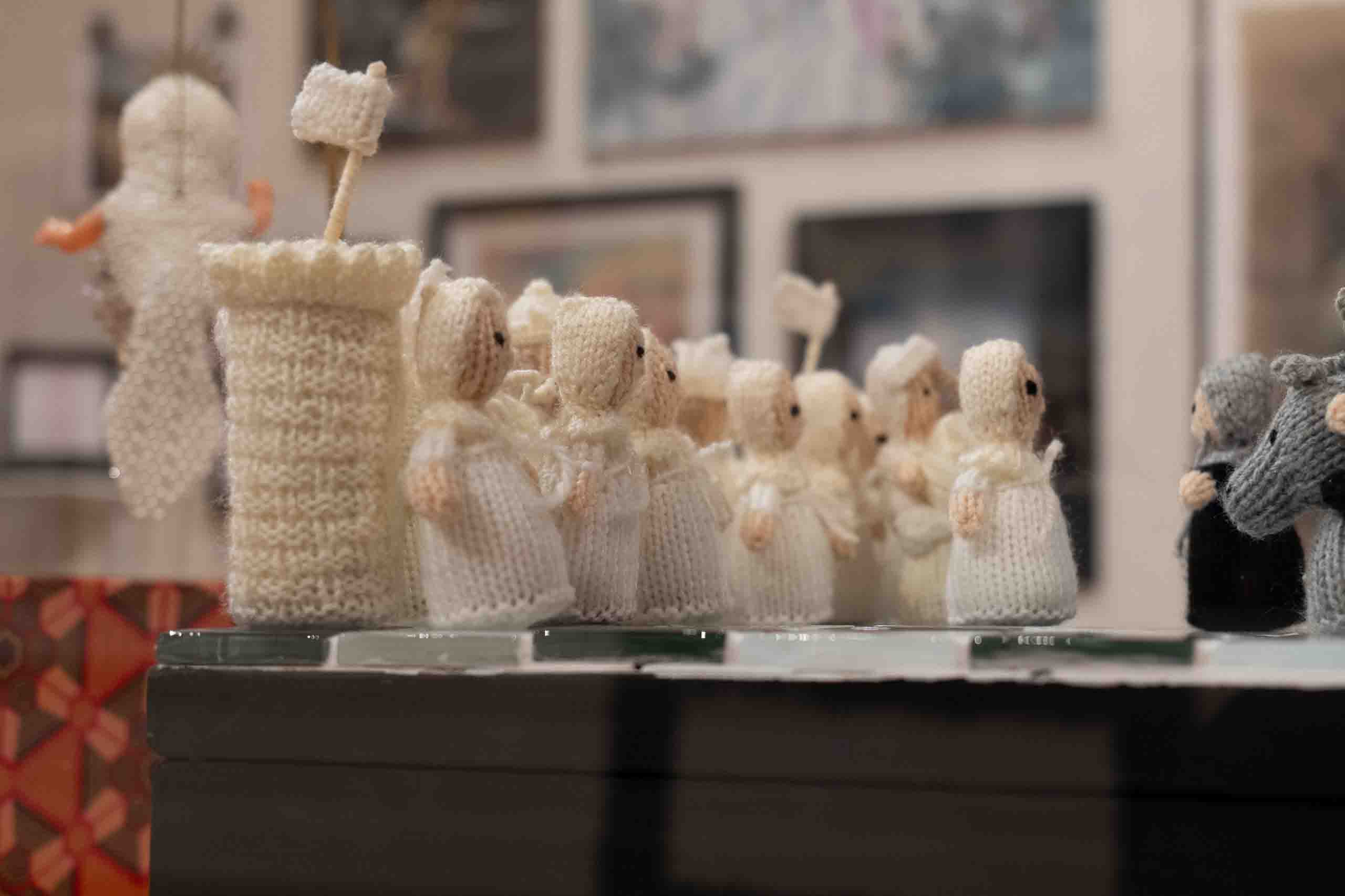 Harris Museum Open Exhibition 2026 — close-up detail of hand-knitted white figurines arranged as a procession on a display plinth
