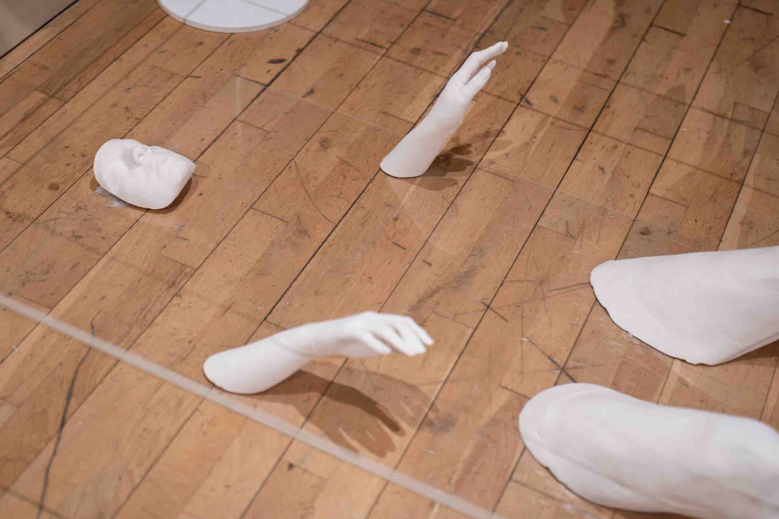 Harris Museum Open Exhibition 2026 — floor-level view of white plaster sculptural hands and legs from the fragmented body installation