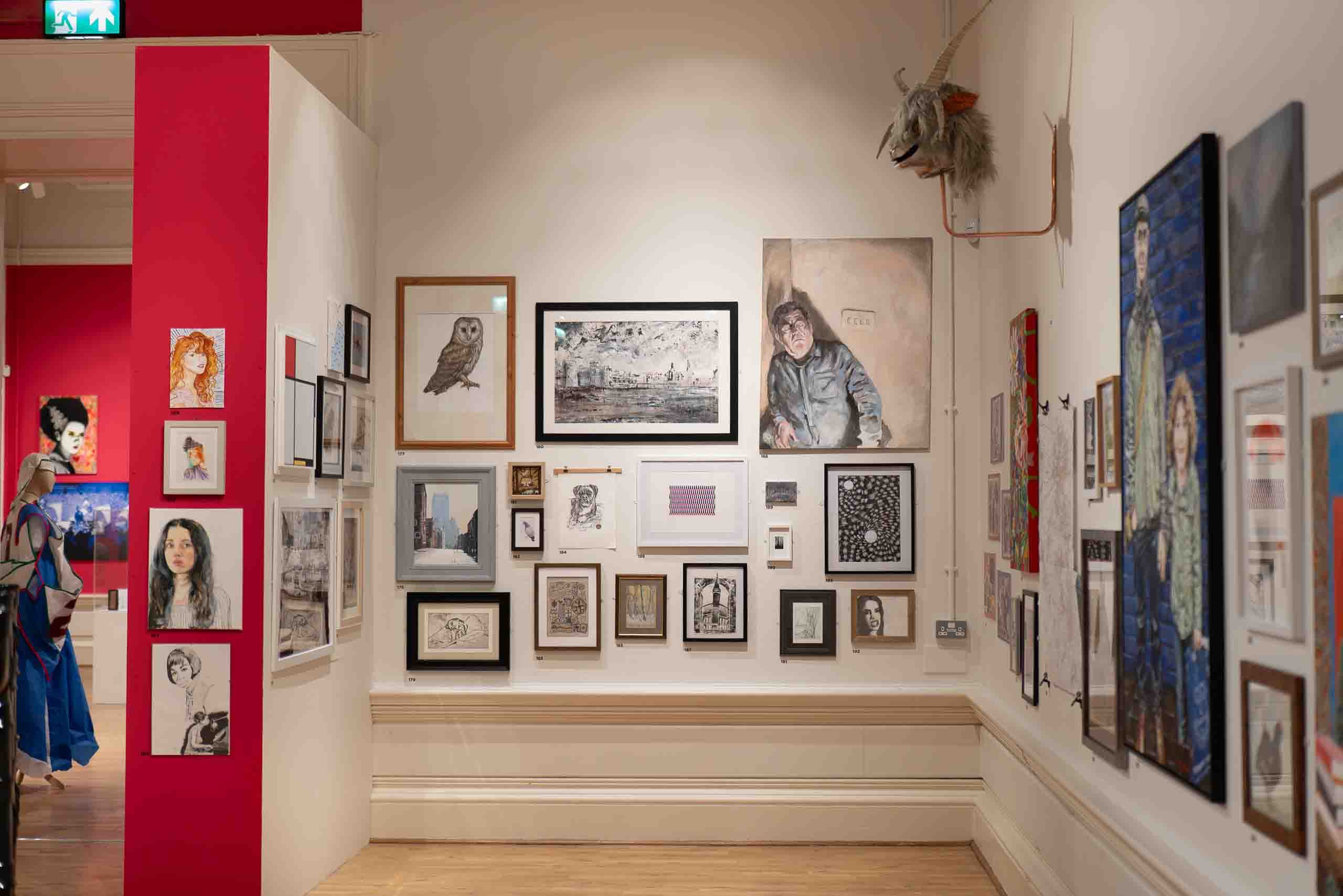 Harris Museum Open Exhibition 2026 — white gallery wall hung with pencil drawings, prints, an owl illustration and a large figurative oil painting
